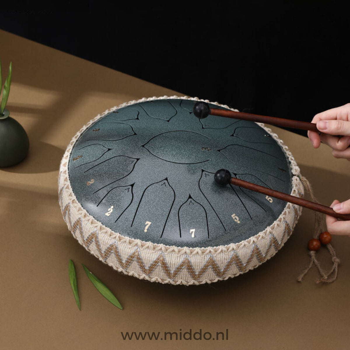 Hände spielen eine Jade Harmonii KlankOase Steel Tongue Drum mit Schlägeln
