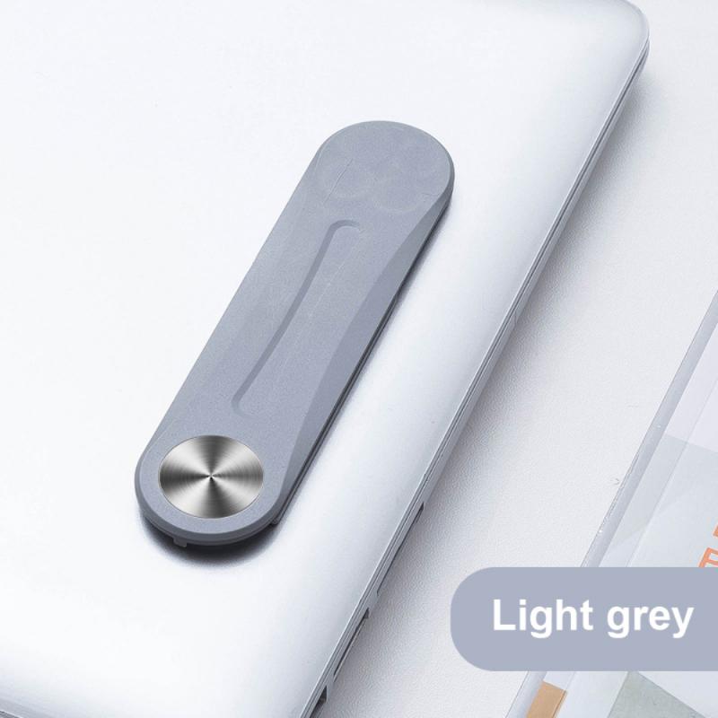 Graue magnetische Klammer, die an einem Laptop befestigt ist