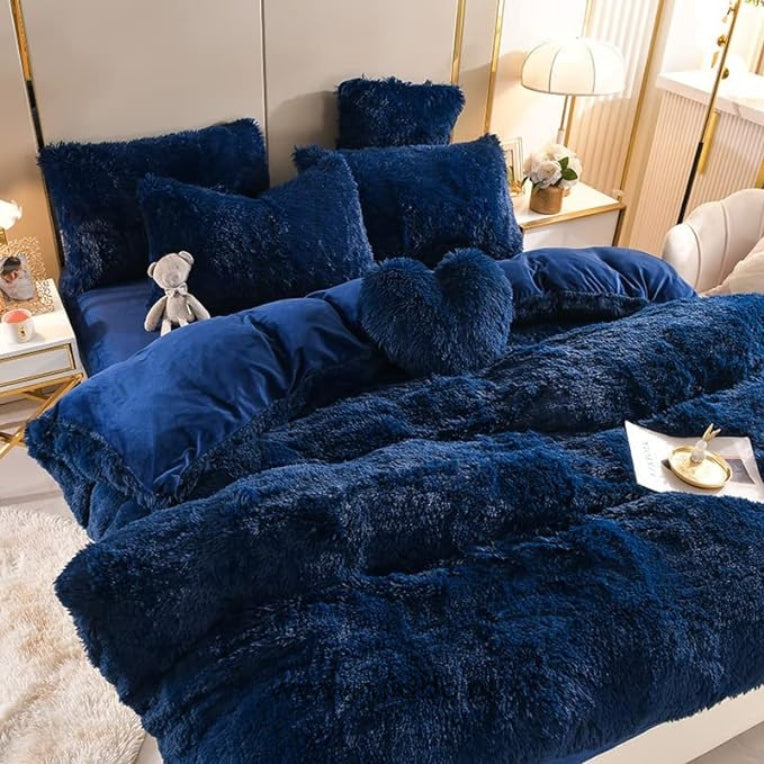 Bild von 5-teiligen dunkelblauen flauschigen Fleece-Bettwäsche mit kostenlosem Herz-Kissen, ordentlich auf einem Bett mit einem kleinen grauen Kuschelbären arrangiert.