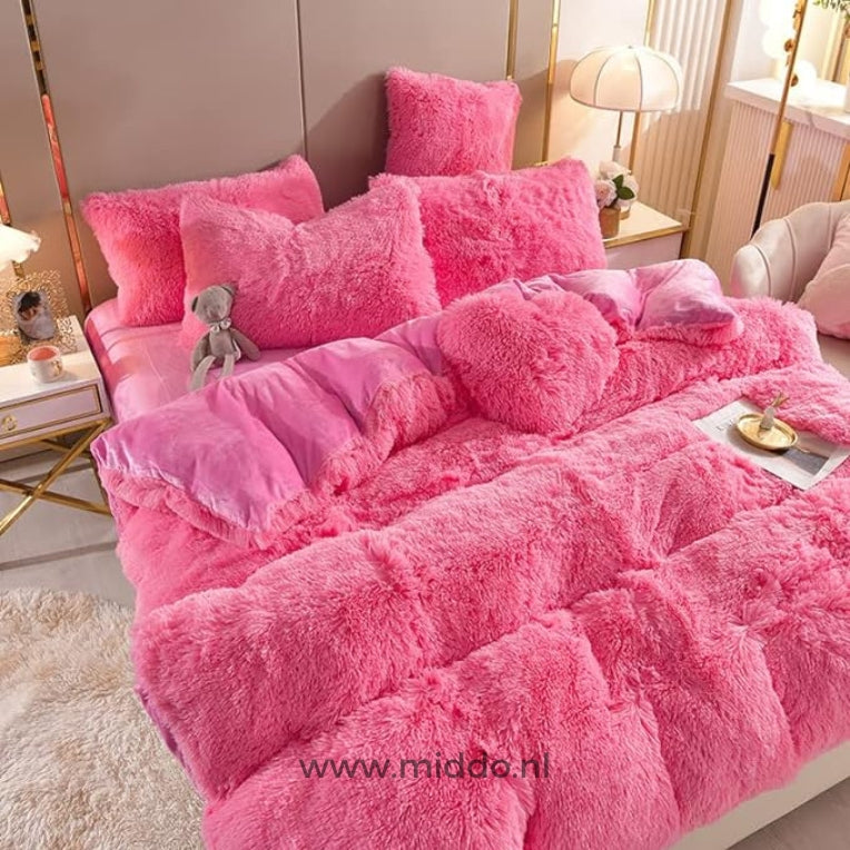 Foto von 5 Sets rosa, flauschiger Fleece-Bettwäsche mit kostenlosem Herz-Kissen, ordentlich auf dem Bett drapiert, zusammen mit einem kleinen grauen Kuschelbären.