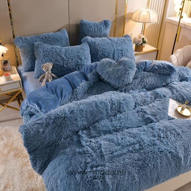 Foto von 5 Teilen blauen flauschigen Fleece-Bettwäsche mit kostenlosem Herz-Kissen, ordentlich auf dem Bett arrangiert, mit einem kleinen grauen Plüschbär.