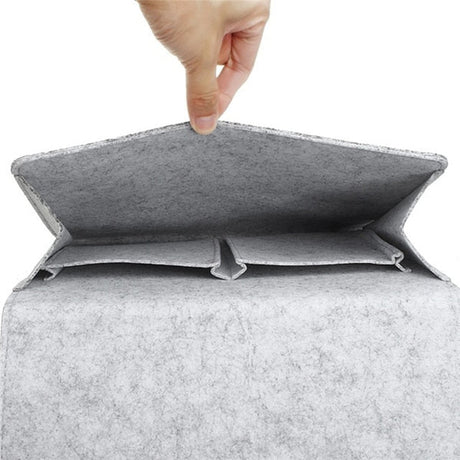 Eine Hand hält die hellgraue BedCaddy geöffnet, sodass du sehen kannst, wie es von innen aussieht
