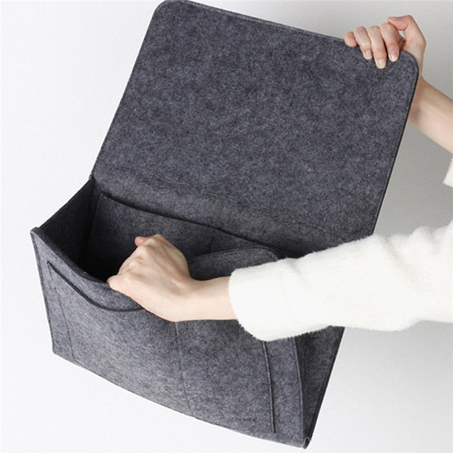 Eine Dame hält einen grauen BedCaddy in der Hand und hält ihn leicht geöffnet.