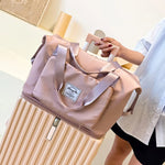 Dame hält einen Rollkoffer in der Hand, auf dem eine Beggo Reisetasche liegt.