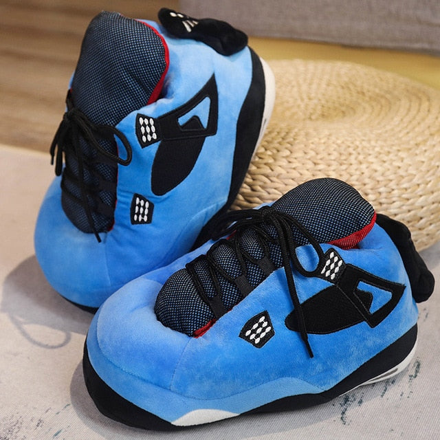 Blaue Slippersneaker mit schwarzen und roten Akzenten, Rattanuntergrund.
