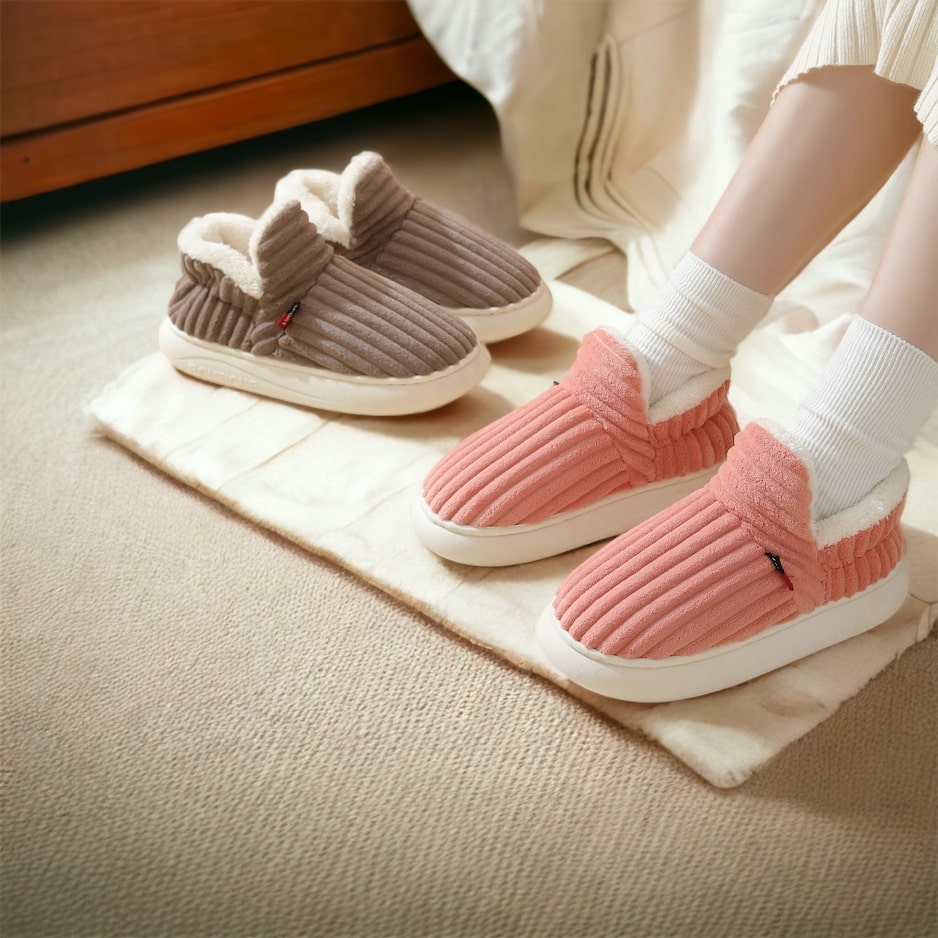 Person trägt rosa und braune CozyComfort Hausschuhe mit weißem Fleece-Futter.