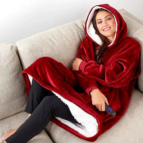 Person trägt einen roten Sherpa-Fleece-XXL-Hoodie und entspannt sich auf der Couch