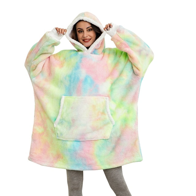 Eine Person trägt einen bunten XXL Hoodie mit Regenbogenmuster.