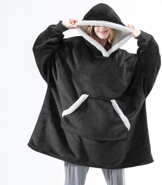 Person trägt einen schwarzen Sherpa Fleece XXL Hoodie mit weißem Rand.