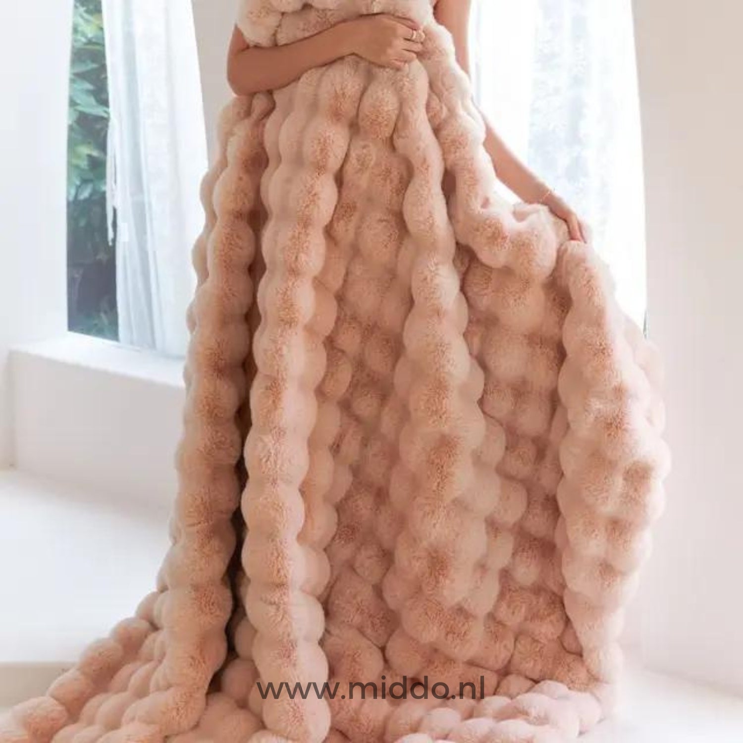 Frau in rosa flauschiger Decke am Fenster