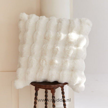 Fluffy Kissen mit dekorativer Textur auf einem Hocker