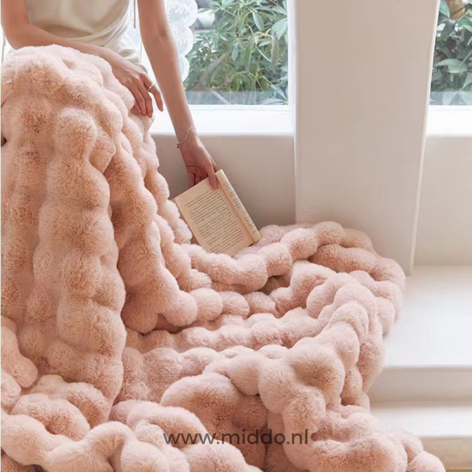 Rosa flauschige Decke über der Couch Frau liest Buch