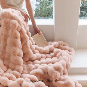 Rosa flauschige Decke über der Couch Frau liest Buch