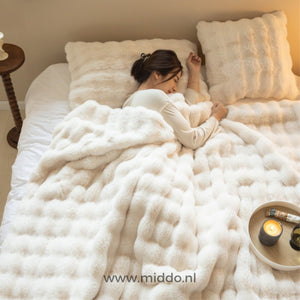 Person schläft unter der Fluffy toskanischen Winterdecke im beigen Schlafzimmer