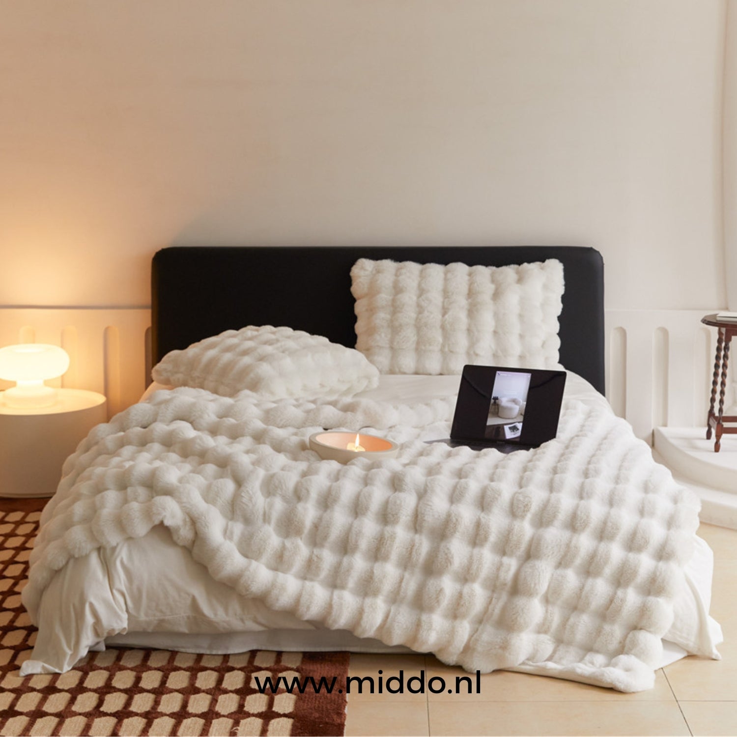 Weiße flauschige toskanische Winterdecke auf dem Bett mit Tablet und Kissen