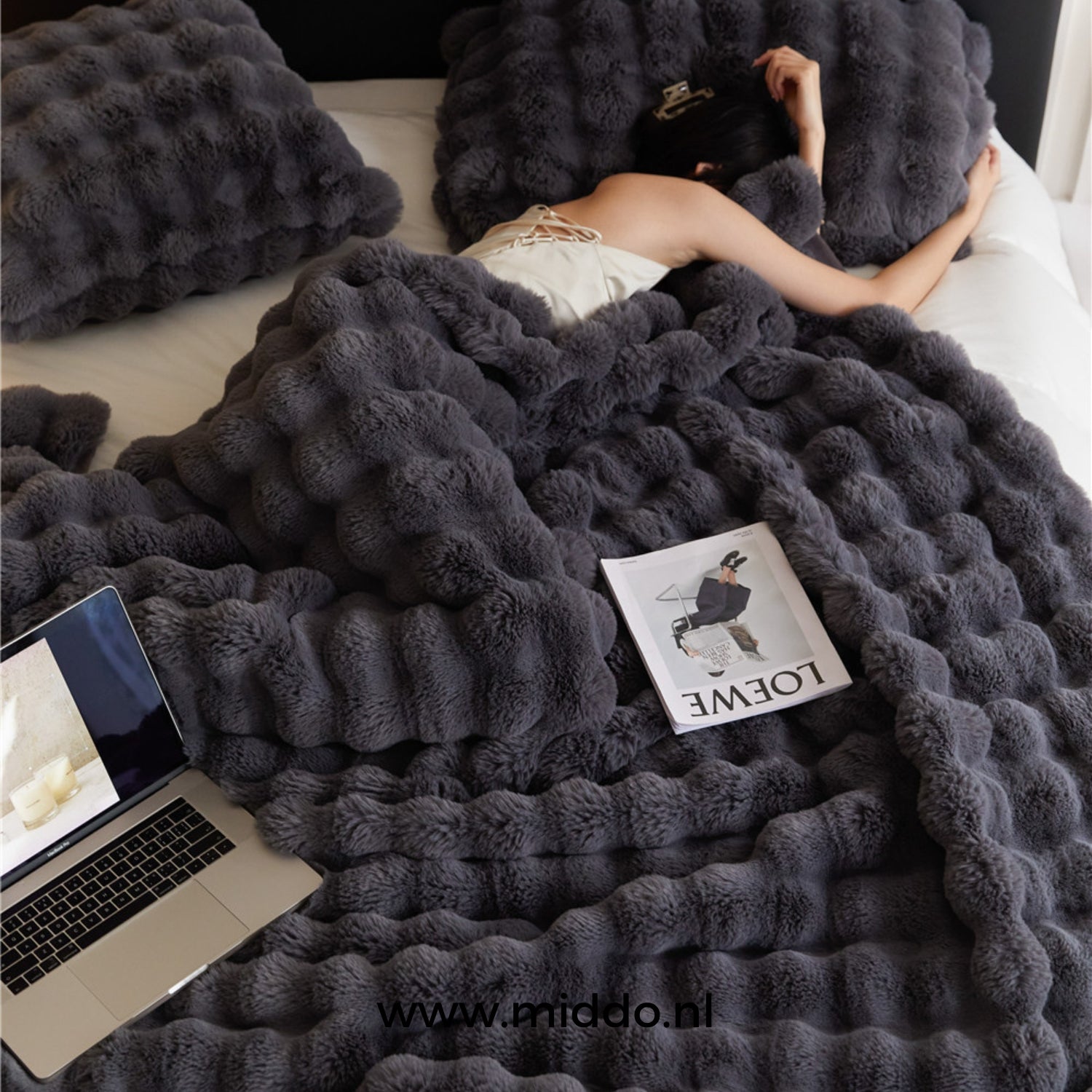 Schwarze Flauschige toskanische Winterdecke auf dem Bett mit Magazin und Laptop