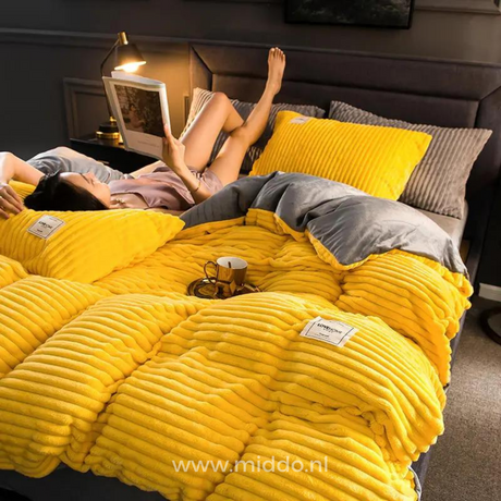 Frau liegt auf dem Bett mit einer Zeitschrift auf einem gelben Bettbezug