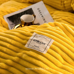 Nahaufnahme von gelber Bettwäsche mit einer Tasse und einem Magazin