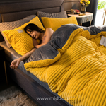 Frau liegt unter dem gelben Samt-Fleece Bettbezug