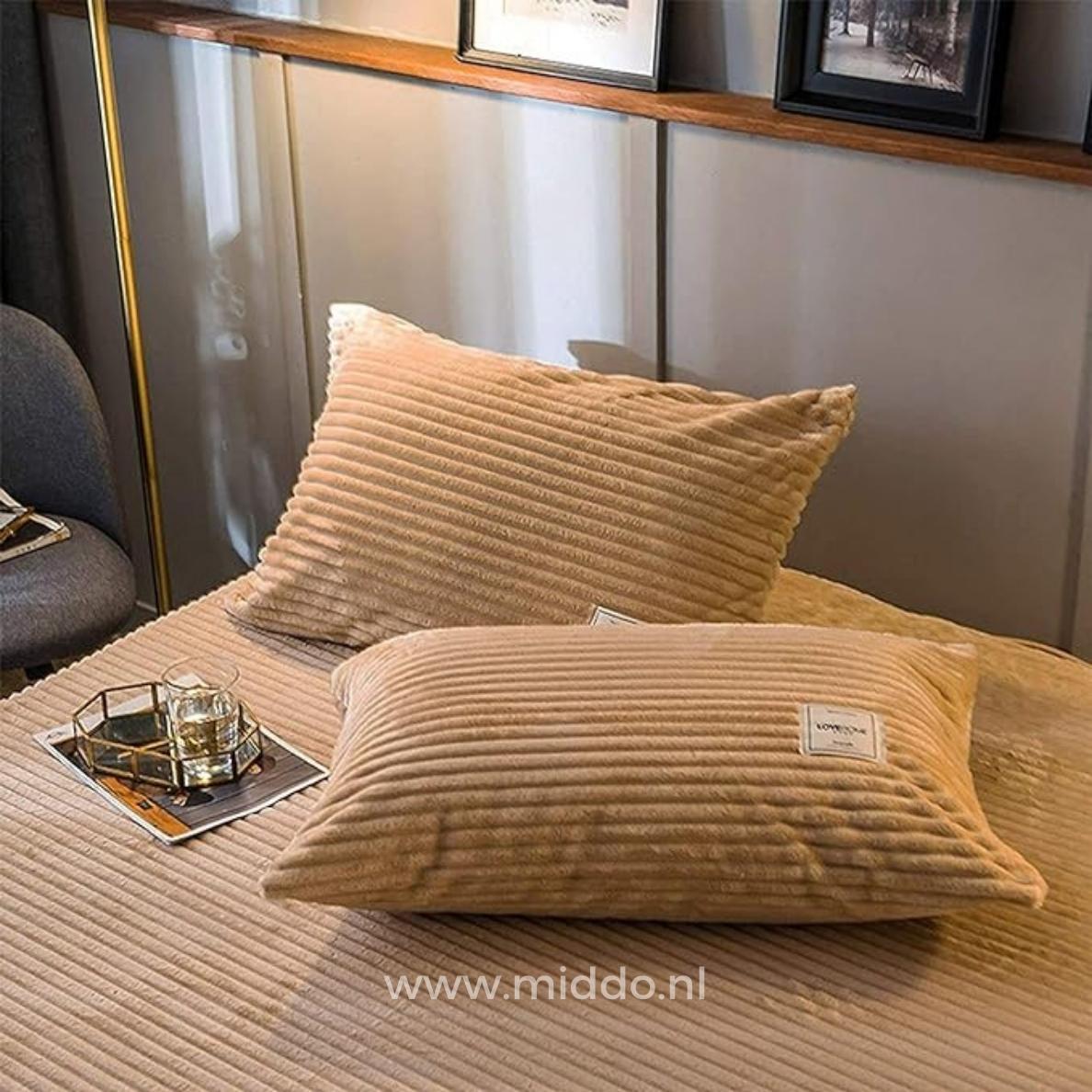 2 Kissen mit beigen Kissenbezügen auf einem Bett
