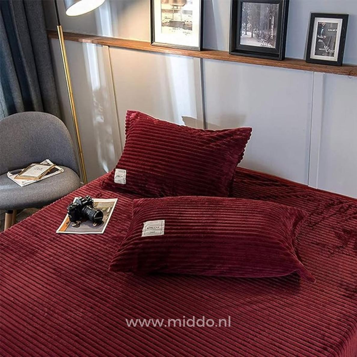 2 Kissen mit weinroten Kissenbezügen auf einem Bett