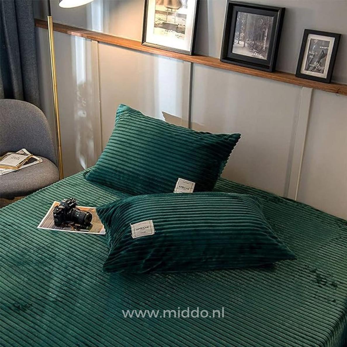 2 Kissen mit dunkelgrünen Kissenbezügen auf einem Bett