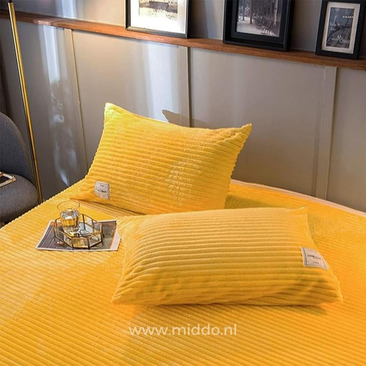 2 Kissen mit gelben Kissenbezügen auf einem Bett