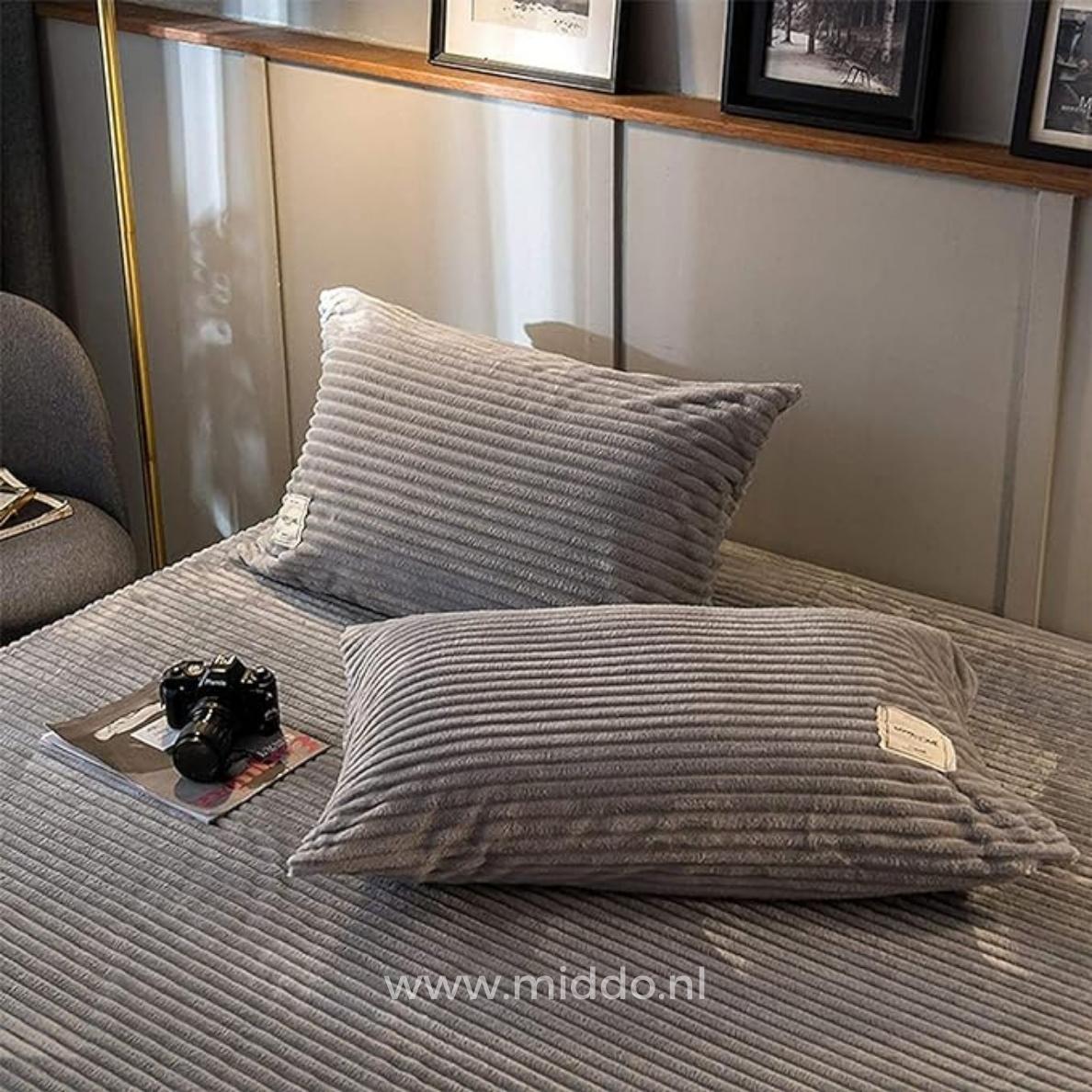 2 Kissen mit grauen Kissenbezügen auf einem Bett