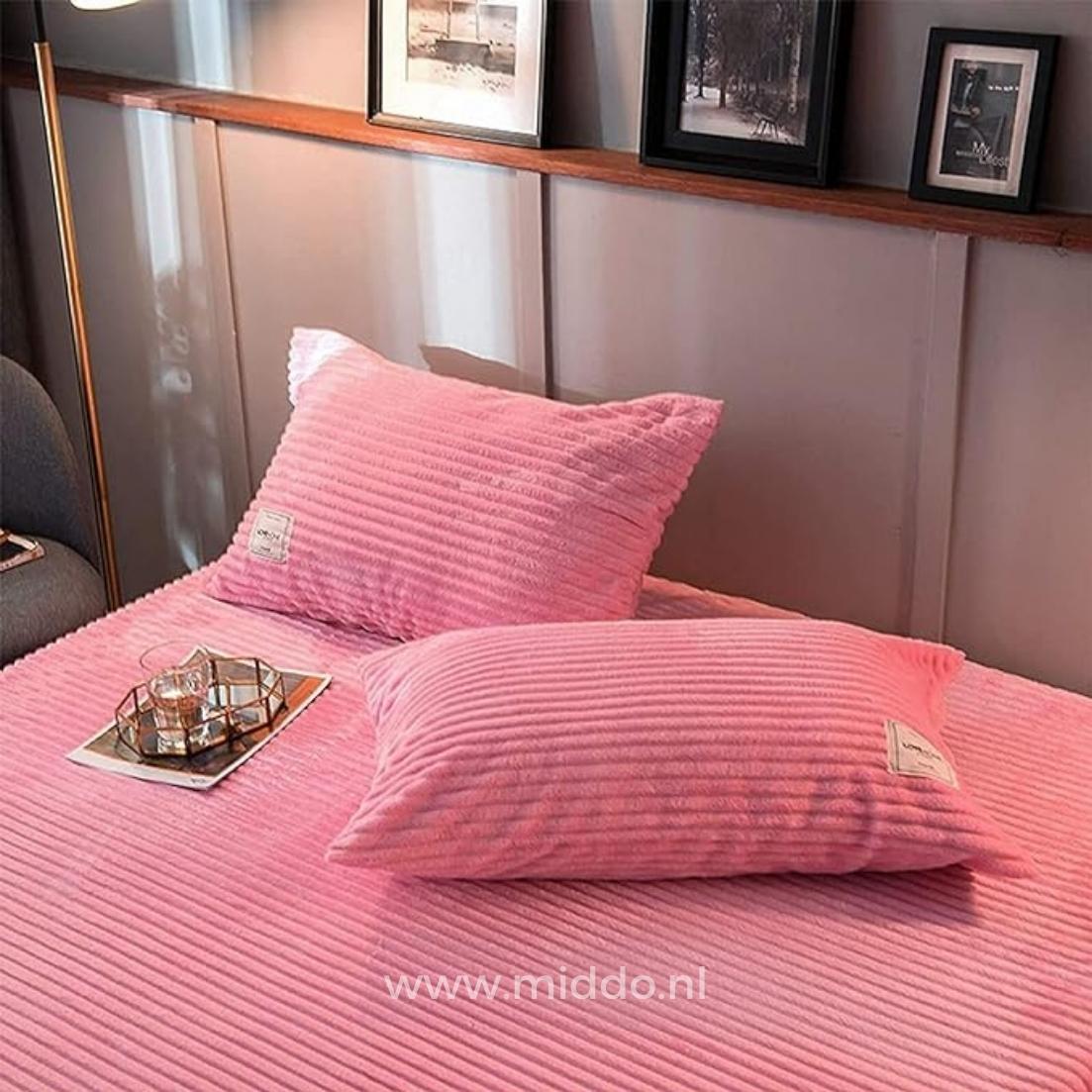 2 Kissen mit rosa Kissenbezügen auf einem Bett