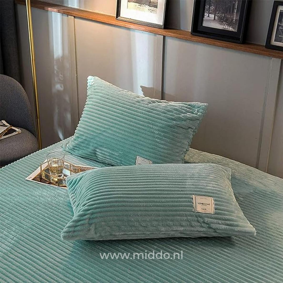 2 Kissen mit jadegrünen Kissenbezügen auf einem Bett