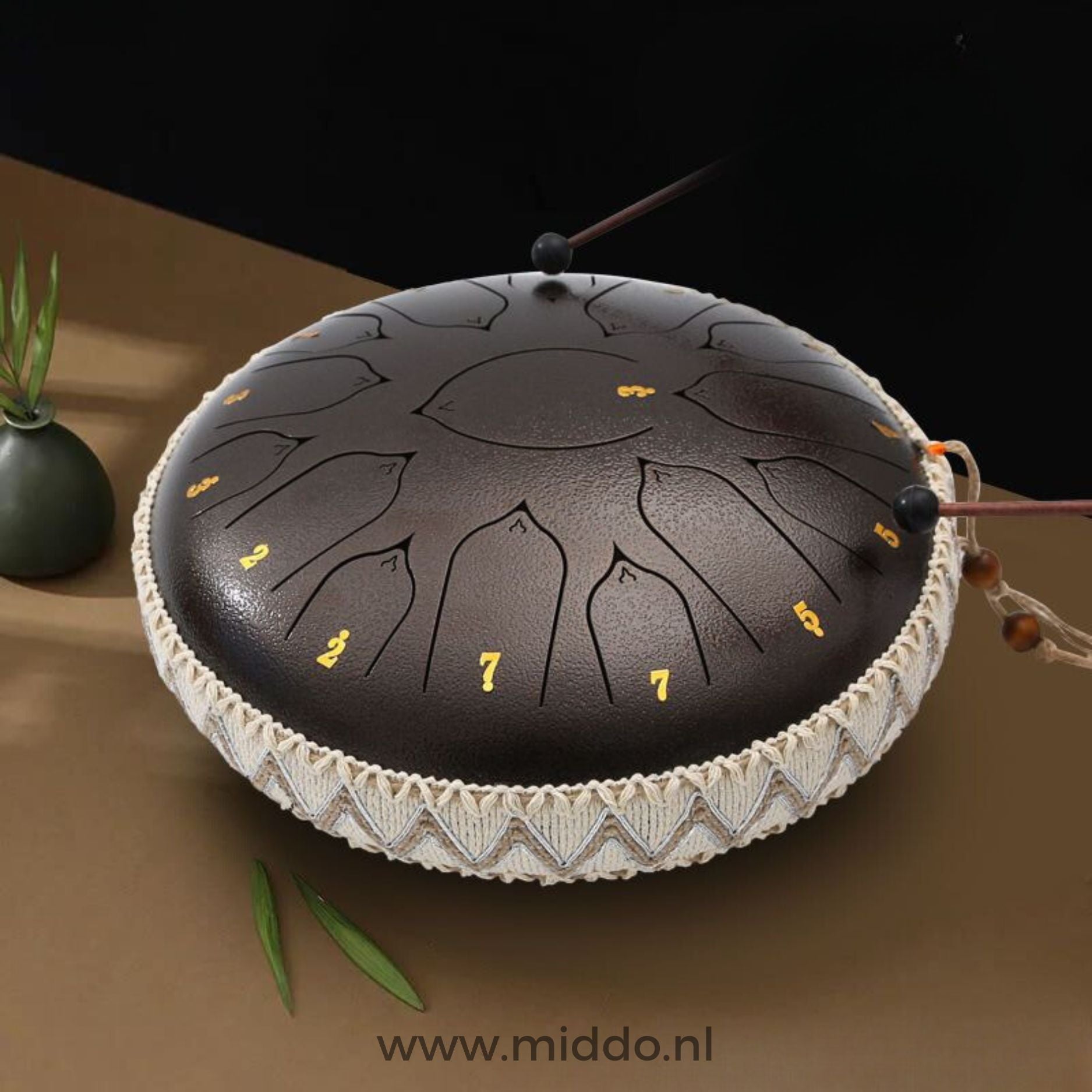 Hände spielen eine bronzene Harmonii KlankOase Steel Tongue Drum mit Schlägeln.