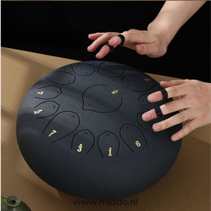 Hände spielen eine schwarze Harmonii KlankOase Steel Tongue Drum mit Fingernägeln