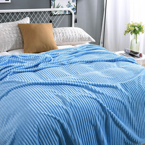 Himmelblaue, samtartige Fleece-Decke auf einem frisch gemachten Bett