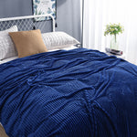 Dunkelblaue Samt-Fleece-Decke auf einem gemachten Bett