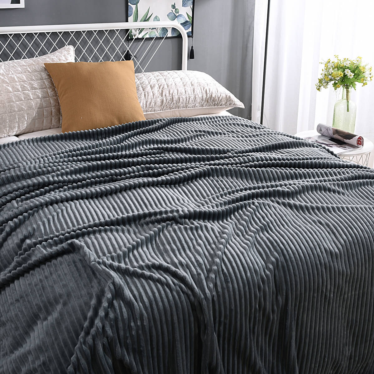 Dunkelgraue Velvet-Fleece-Decke auf einem gemachten Bett