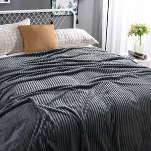 Dunkelgraue Velvet-Fleece-Decke auf einem gemachten Bett