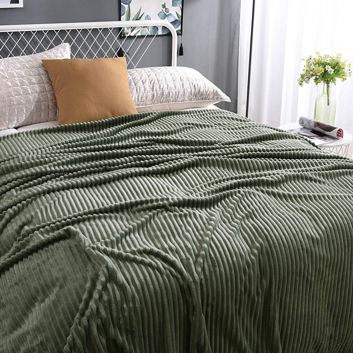 Grüne, samtige Fleece-Decke auf einem gemachten Bett