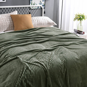 Grüne, samtige Fleece-Decke auf einem gemachten Bett