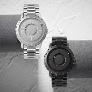 Silberne und schwarze Uhr nebeneinander auf einem grauen Hintergrund