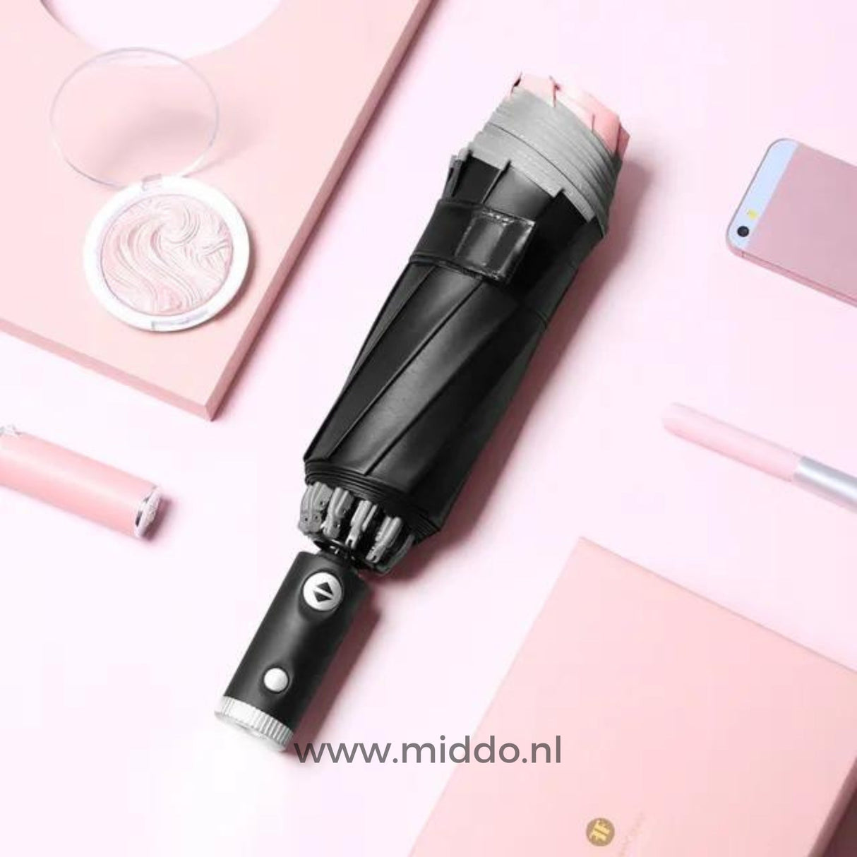 Schwarzer Regenschirm mit reflektierendem Rand, Handy und Stift auf rosa Hintergrund