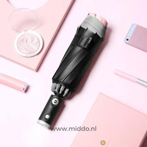 Schwarzer Regenschirm mit reflektierendem Rand, Handy und Stift auf rosa Hintergrund