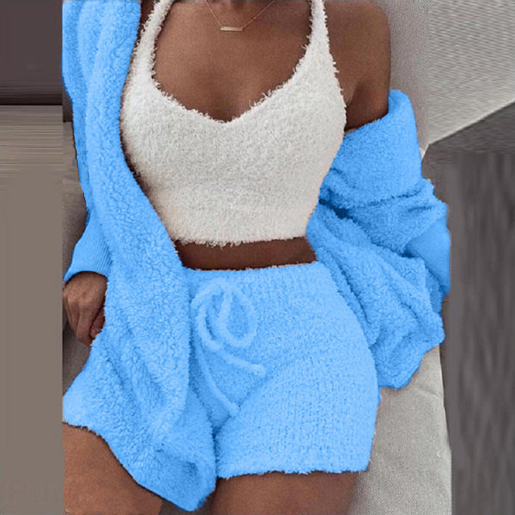 Frau in blauen SheCutie Comfy Set mit Shorts, Top und Cardigan, die auf der Couch sitzt.