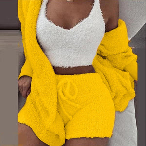 Frau in gelbem SheCutie Comfy Set mit Shorts, Top und Blazer auf grauem Hintergrund