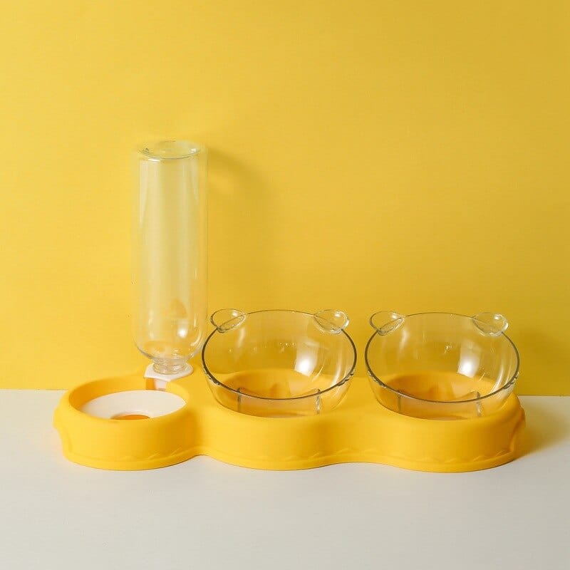 Gelbes Futtertablett mit Futterschalen und Wasserspender.