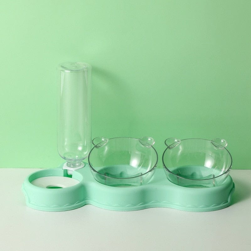 Grüne Futterplatte mit Futterbehältern und Wasserspender.