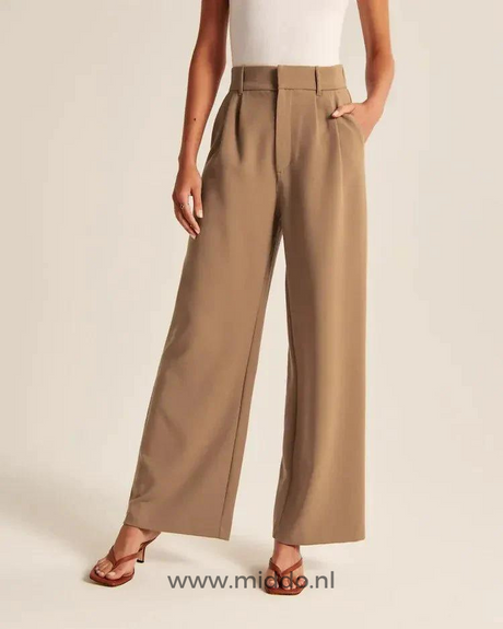 Eine Dame präsentiert die braune weite Hose mit 2 Eingrifftaschen und trägt braune hochhackige Sandalen