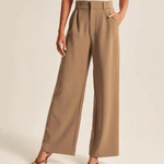 Eine Dame präsentiert die braune weite Hose mit 2 Eingrifftaschen und trägt braune high-heeled Sandalen.