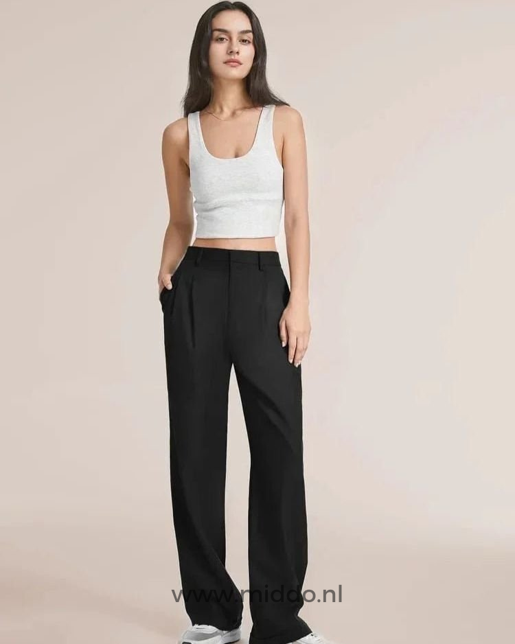 Eine schlanke Dame präsentiert die schwarze weite Hose mit einem weißen Oberteil darüber.