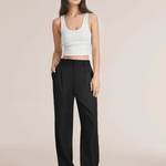 Eine schlanke Dame präsentiert die schwarze weite Hose mit einem weißen Oberteil darüber.