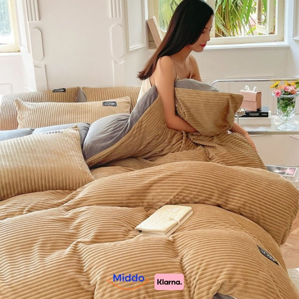 Frau sitzt auf dem Bett mit beigem Fleece-Bettbezug und liest ein Buch.